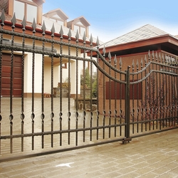 Kovaná brána a plot s hrotmi pri rodinnom dome