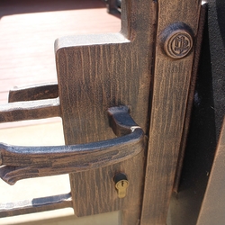 Detail bránky s ručne kovanou kľučkou a pečaťou UKOVMI