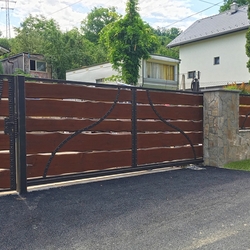 Kovaná brána a plot s plnou drevenou výplňou zabezpečí dokonalé súkromie